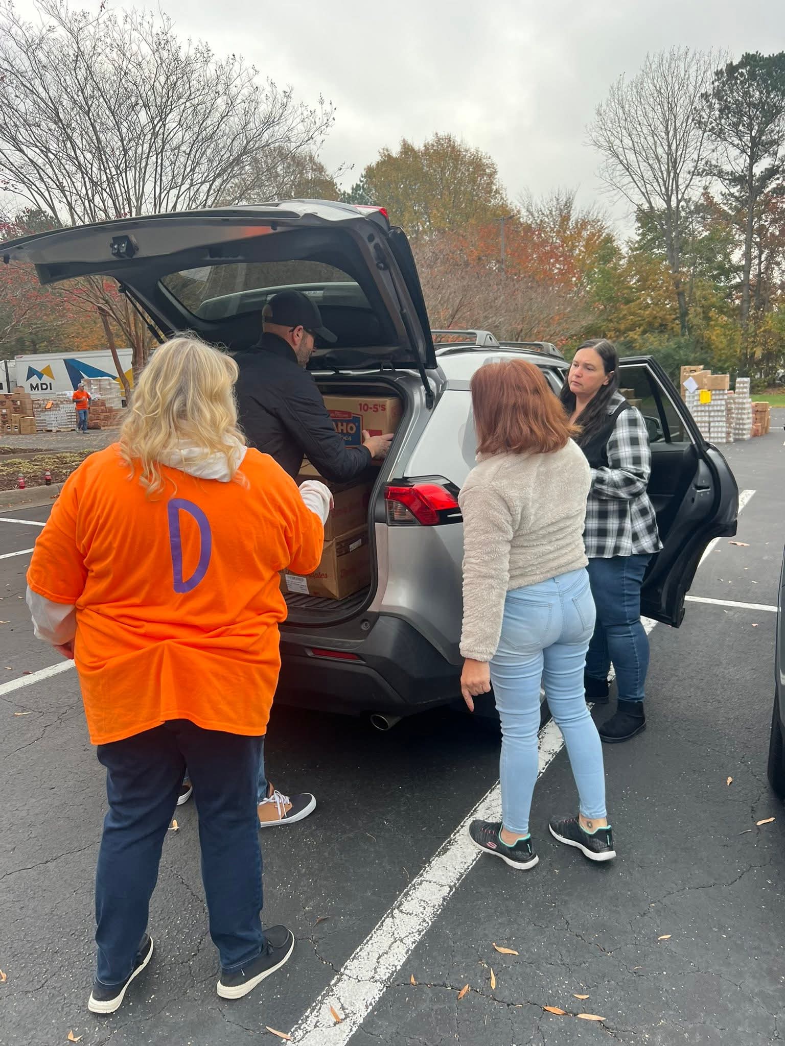 Volunteers loading Thanksgiving donations into a car