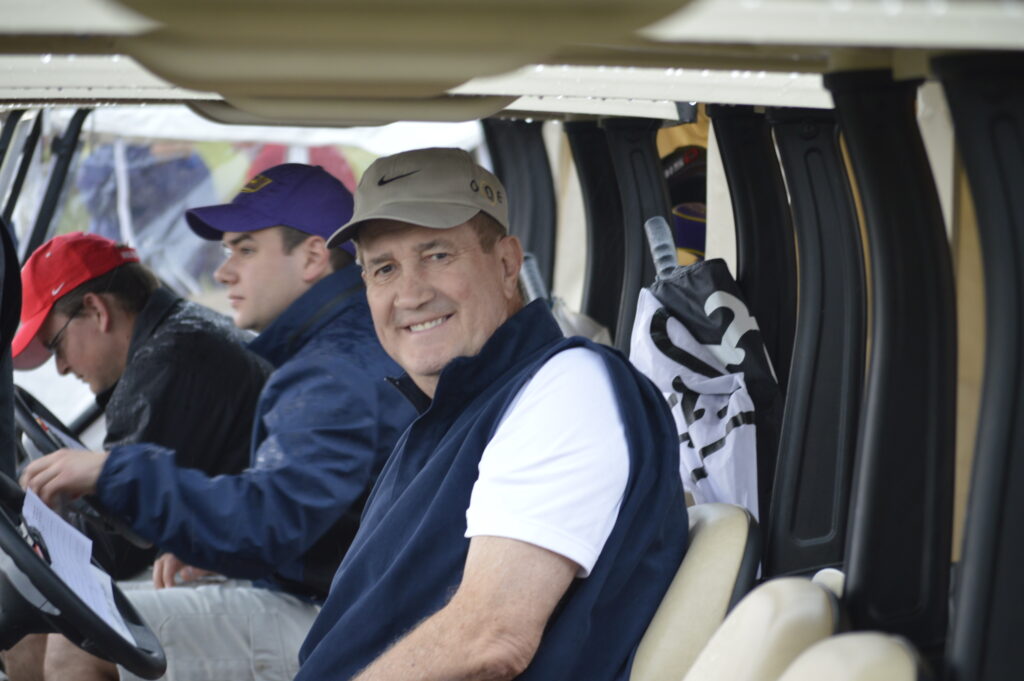 Golfers riding in golf carts at the tournament