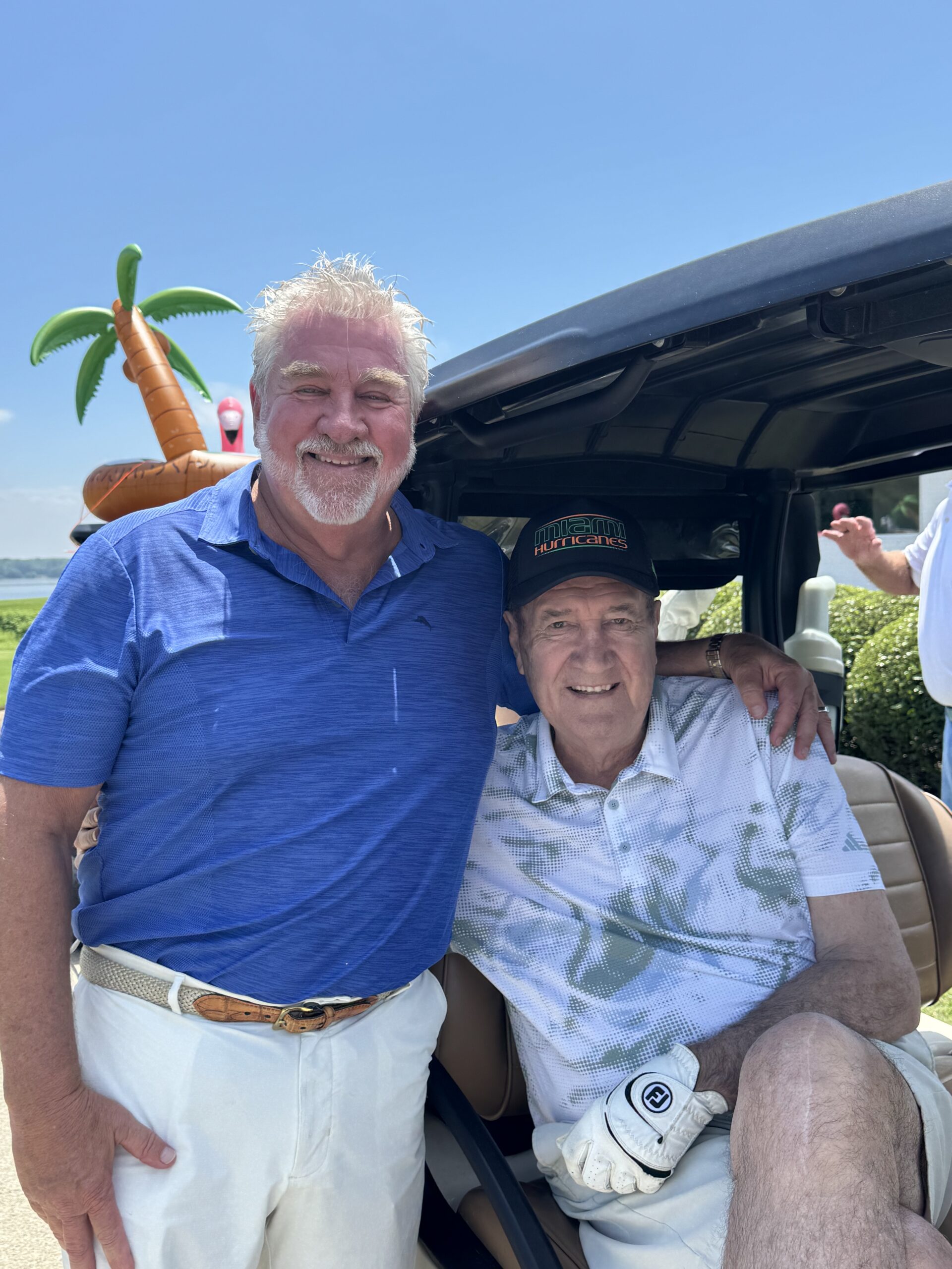 Two golfers smiling in a golf cart