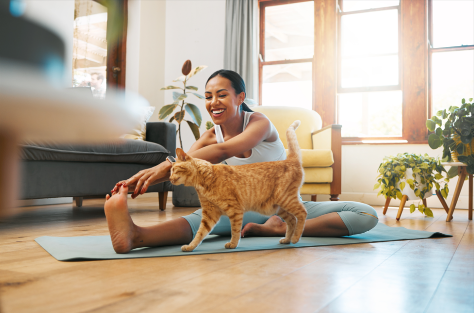 Woman doing yoga at home with her dog